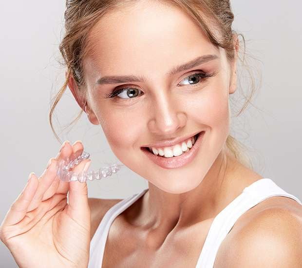 young woman holds invisalign tray