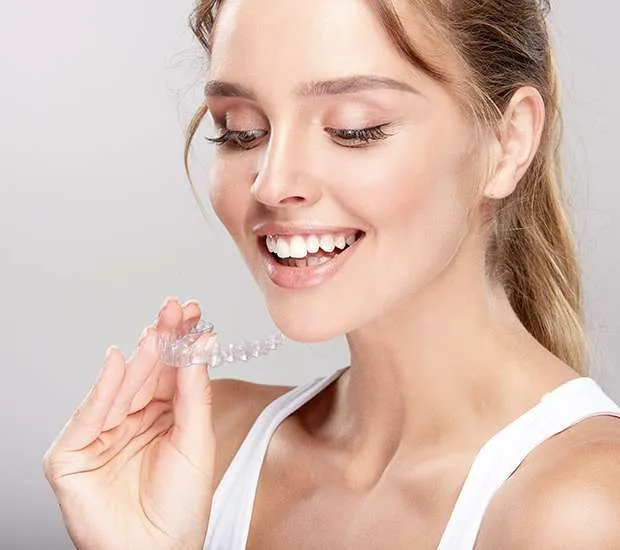 woman holds invisalign tray